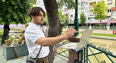 İlk kez geldiği şehrin sokaklarını gezerken sulu boya ile resmediyor