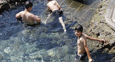 Sıcaktan bunalan çocuklar süs havuzunda serinliyor