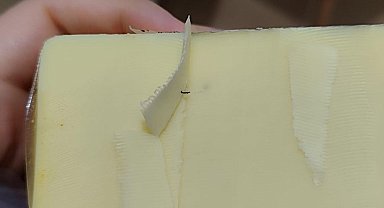 Kaşar peynirinin içinden çıkan siyah cisim karşısında hayrete uğradı