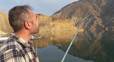 Sular altında kalan ilçede baraj gölünde oltayla balık tutulmaya başlandı