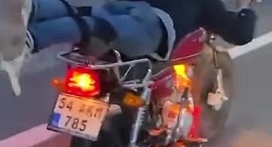 Motosikleti, üzerine yüzüstü yatarak kullanan sürücü kamerada