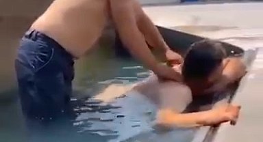 Sıcaktan bunalan işçiler, iş makinesinin kovasına doldurdukları suda serinledi