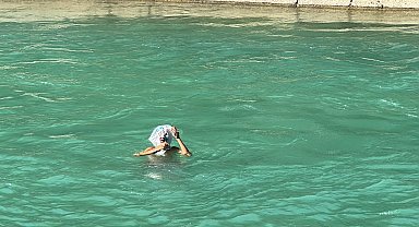 Adana'da kanala giren çocuklar, başlarına kese kağıdı ve poşet geçirip yüzdü