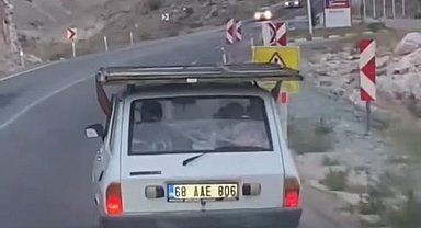 Otomobilin üstündeki demir kapıyla tehlikeli yolculuk