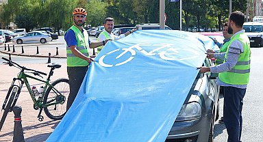 Bisiklet yolunu kapatan araçların üzerine branda çekip tepki gösterdiler