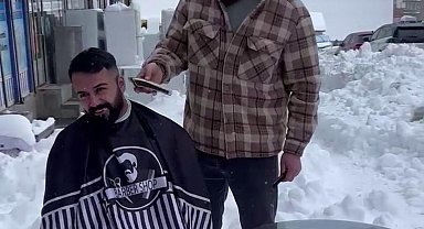 Berber, müşterilerini karda dükkanının önünde tıraş etti