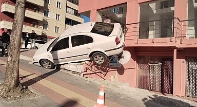 Çorum'da otomobil apartman girişindeki dükkanın merdivenine çıktı