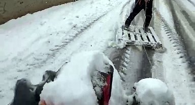 Karla kaplı sokakta ahşap palet ile snowboard