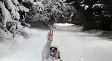 Otomobilin arkasına taktığı şambrelle kayak yaptı