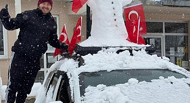 Aracının üzerine yerleştirdiği kardan adam ile şehir turu attı