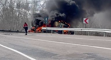 TIR devrildi, üzerindeki iş makinesi alev aldı; 3 yaralı