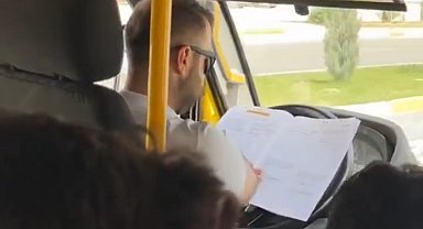 Minibüs şoförü, direksiyonda kitap okurken görüntülendi